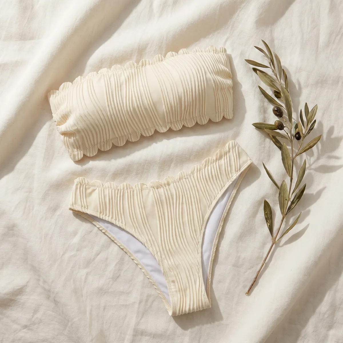 Maillot Salins, bandeau festonné écru, à plat sur lin naturel.